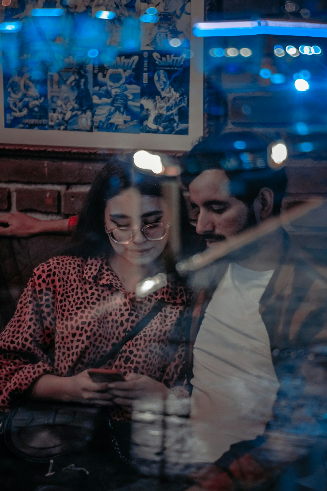 Photo by Javier González Fotógrafo a man and woman sitting at a table with a phone