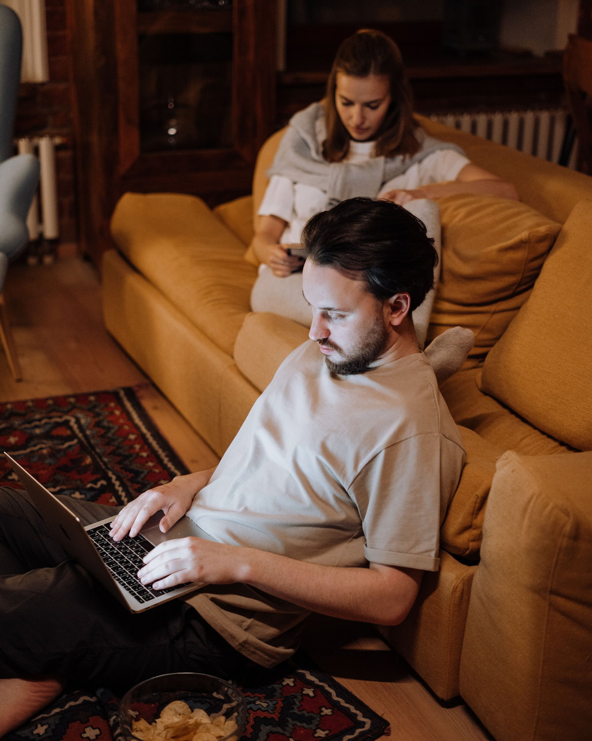 Ein Paar sitzt abends nebeneinander auf dem Sofa
